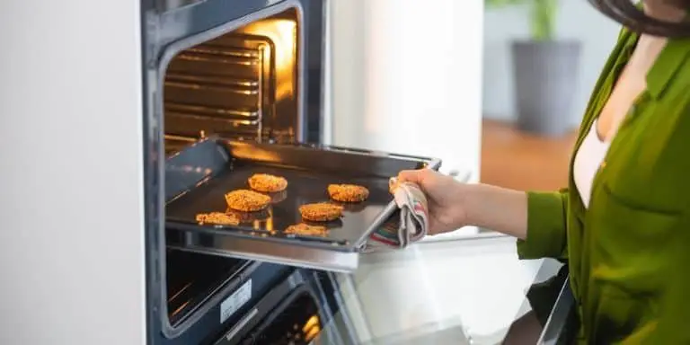 Woman checking the biscuits from a convection oven