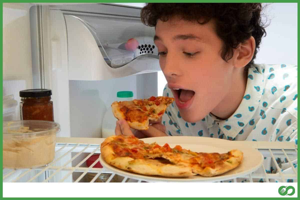 Kid eating pizza from the fridge