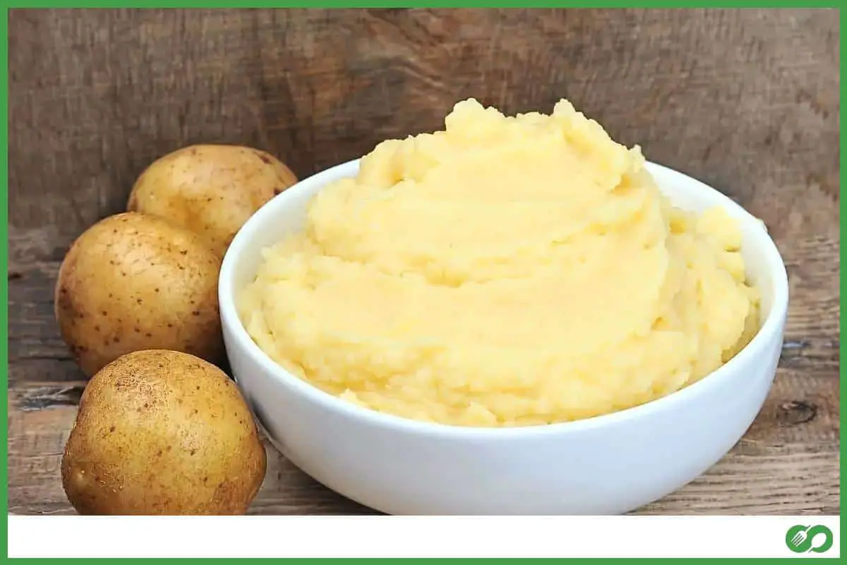Bowl of mashed potatoes with potatoes on the side